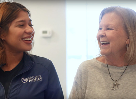 dental implant patient smiling with team member