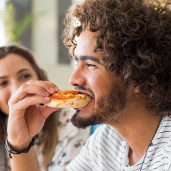 Closeup of man eating lunch with friend