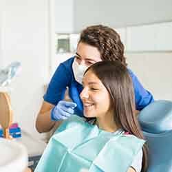 Dental assistant showing patient braces in reflection