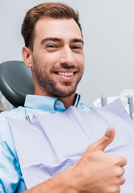 Male dental patient giving thumbs up after full mouth reconstruction in Sachse, TX