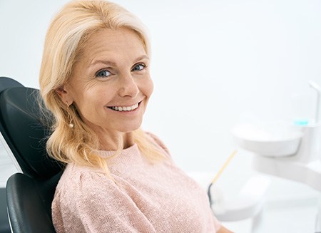 Senior woman sitting in dental chair and smiling