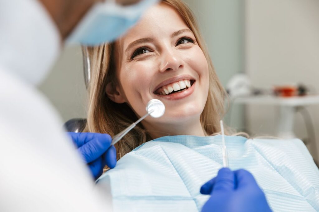 A woman smiling in a dentist's chair.